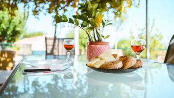 A table with a plate of food, a glass of red wine, and a potted plant.