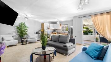 A modern living room with a sofa, a coffee table, and a flat-screen TV.