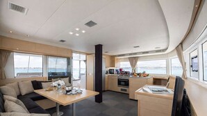 Interior moderno com área de refeições, cozinha e espaço para sentar.