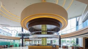 Un vestíbulo moderno con un diseño circular central, un mostrador de recepción y un frente de vidrio.