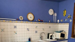 A kitchen with a gas stove, oven, sink, and microwave. - Villa Verabetta (Piano di Sopra)