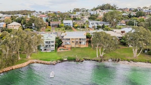 A residential area with houses, a swimming pool, and a boat on the water. - Pelican Sands, 4/83 Soldiers Point Road (Soldiers Point)