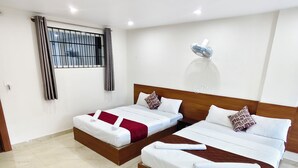 Habitación de hotel con dos camas, una ventana con rejas, ventilador de techo y piso de mármol.