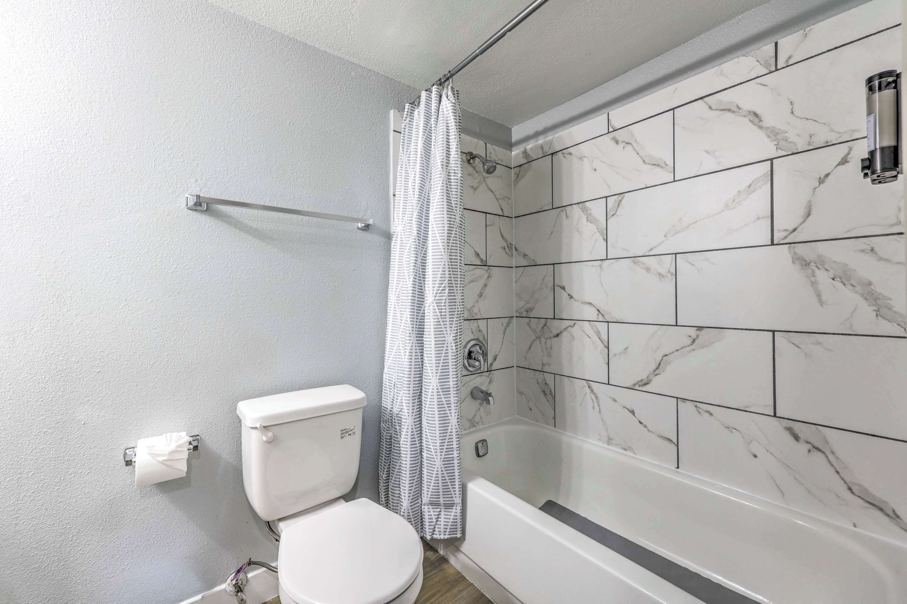 A bathroom with a toilet, shower, and bathtub.