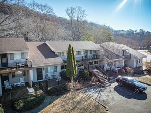 A multi-story motel with a central staircase, outdoor seating, and a parking lot. - Family-friendly, waterfront, 2-bedroom condo inside Rumbling Bald, on Lake Lure (Lake Lure)