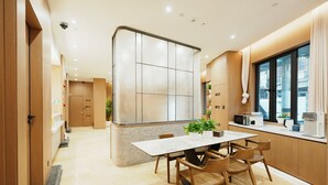 A modern kitchen with a marble countertop, wooden chairs, a central island, and a window with curtains. - Shanghai Weikesun Business Hotel (Shanghai)