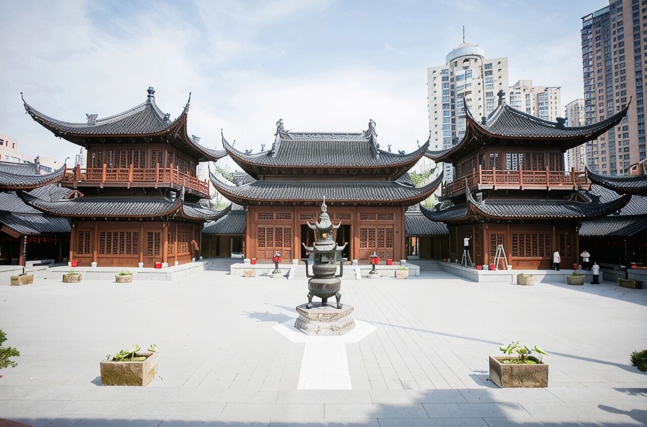 Une cour traditionnelle chinoise, agrémentée de bâtiments richement décorés et d’une statue centrale.