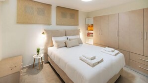 Une chambre à coucher comprenant un lit, une table de chevet, une commode et une armoire.