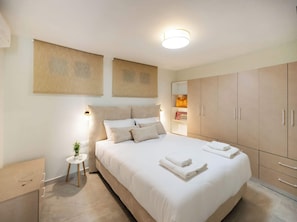 A bedroom with a bed, bedside table, nightstand, and wardrobe. - Boukamvillia Apartment, just 500m from Nidri Beach (Nydri)