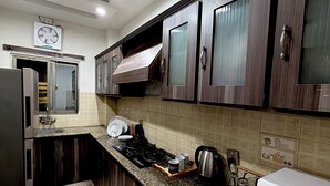 Eine moderne Küche mit dunklen Holzschränken, einer Granitarbeitsplatte, einer eingebauten Mikrowelle und einem Gasherd.