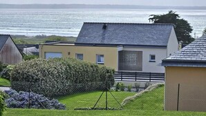 Un quartier résidentiel avec des maisons, une pelouse verdoyante et une vue sur la mer.