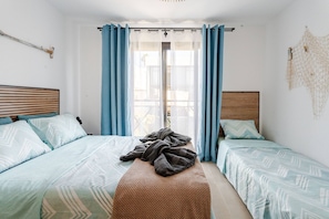 A bedroom with two beds, a bench, and a window with curtains. - 2BR Las Americas, Pool, Terrace, AC, 1Gb Wifi (Arona)