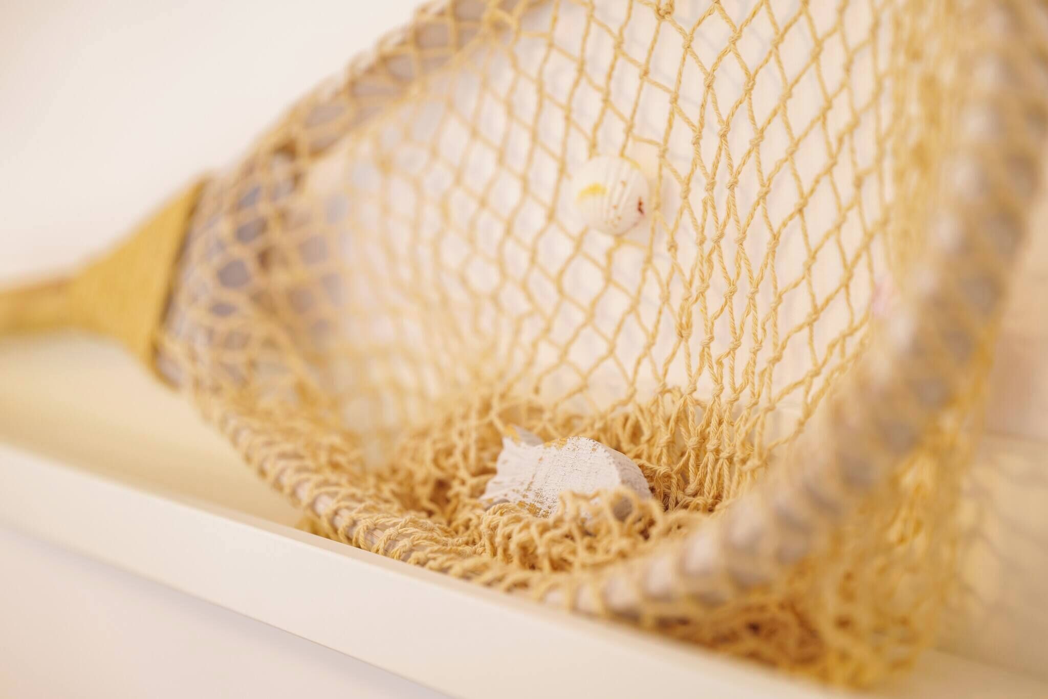 A close-up of a net with a small white object inside.