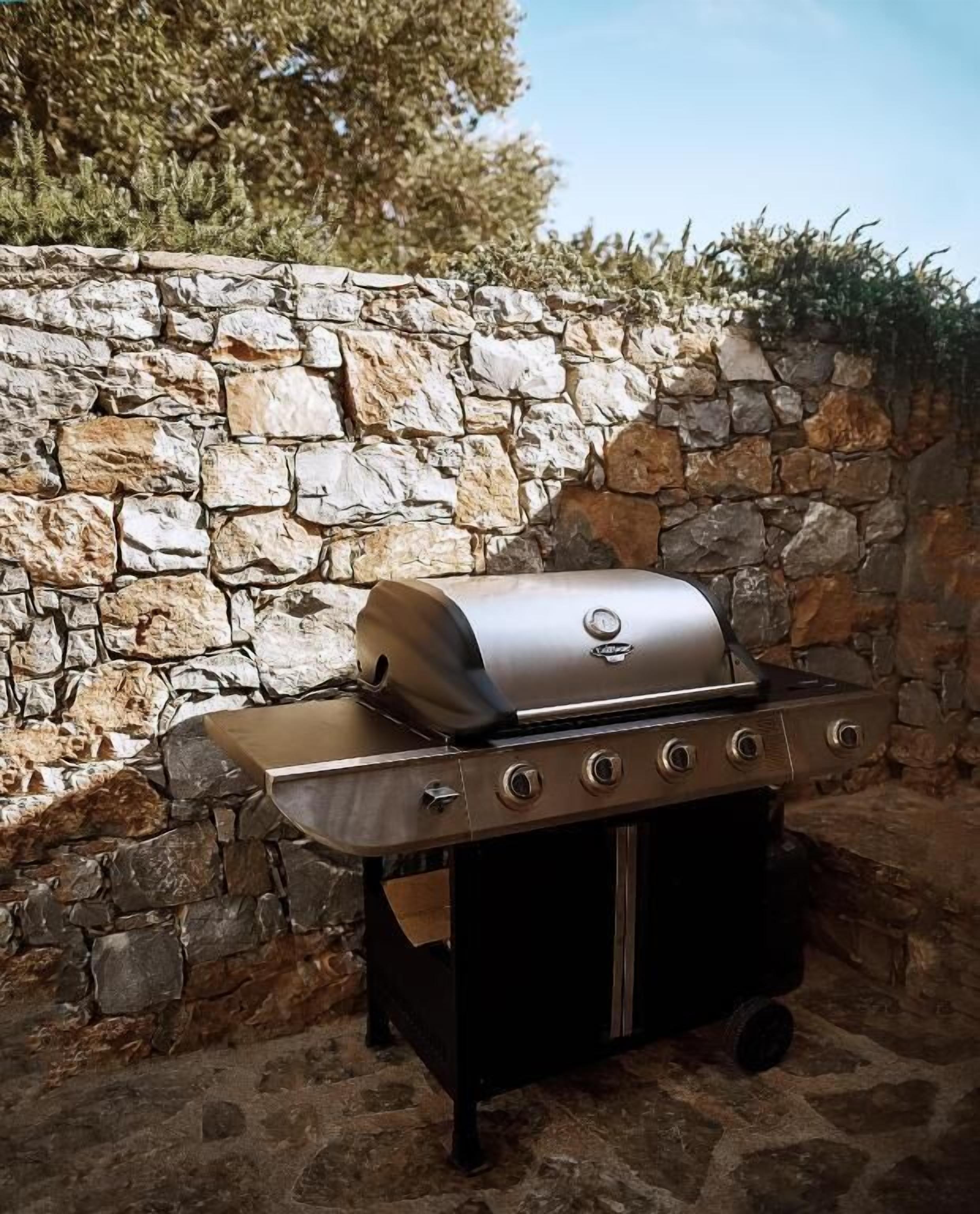 Un muro de piedra, una parrilla y un cielo despejado.