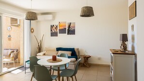 Een moderne woonruimte met een eethoek, een bank en kunst aan de muur.