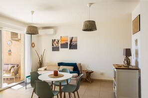 Ein zeitgemäßer Wohnbereich mit Essplatz, einer Couch und Kunstwerken an der Wand.