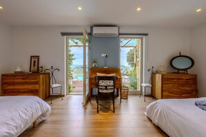A bedroom with two beds, a wooden desk, a chair, a dresser, and a large window with a view. - Villa Labori - Piscine intérieure et extérieure (Gigondas)