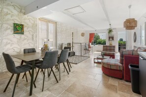 Ein geräumiger Wohnbereich mit Esstisch, Sofas und Blick ins Freie.