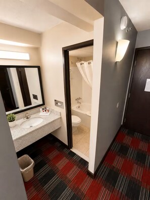 Kylpyhuone, jossa on pesuallas, peili, suihku ja wc.