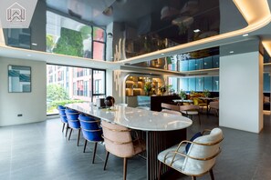 Ein modernes Interieur mit einer zentralen Insellounge, Sitzgelegenheiten und Blick ins Freie.