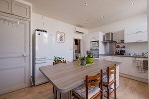 Eine moderne Küche mit weißen Schränken, einem Holztisch und zwei Stühlen.