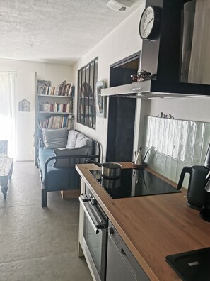 Eine Küche mit Herd, Backofen und einem Essbereich inklusive Tisch und Stühlen.