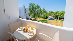 Ein Balkon mit einem Frühstückstisch, komplett mit Croissants, Blaubeeren und Orangensaft.