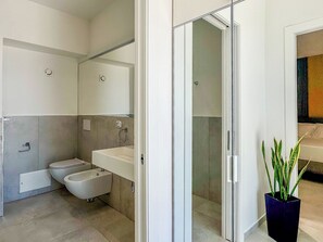 Un bagno moderno con WC, bidet e doccia.