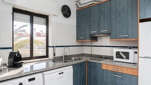 Uma cozinha equipada com máquina de lavar louça, micro-ondas, pia e armários.