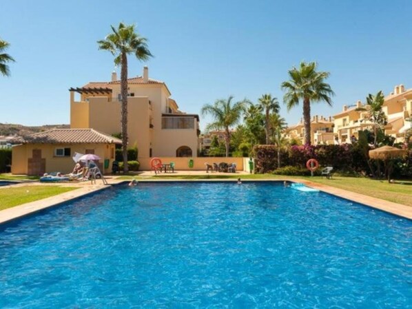 Una piscina rodeada de palmeras y edificios.