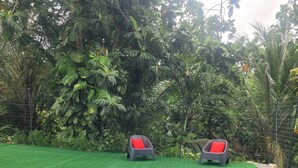 A rectangular pool with a blue edge, surrounded by artificial green grass. - Pom Kanel Vacation Rental with Unobstructed Views (Sainte-Anne)
