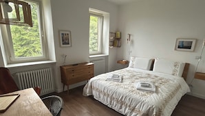 A bedroom with a bed, dresser, chair, and a table. - Il Casale: A Charming Country House in the Monferrato Hills (Colcavagno)