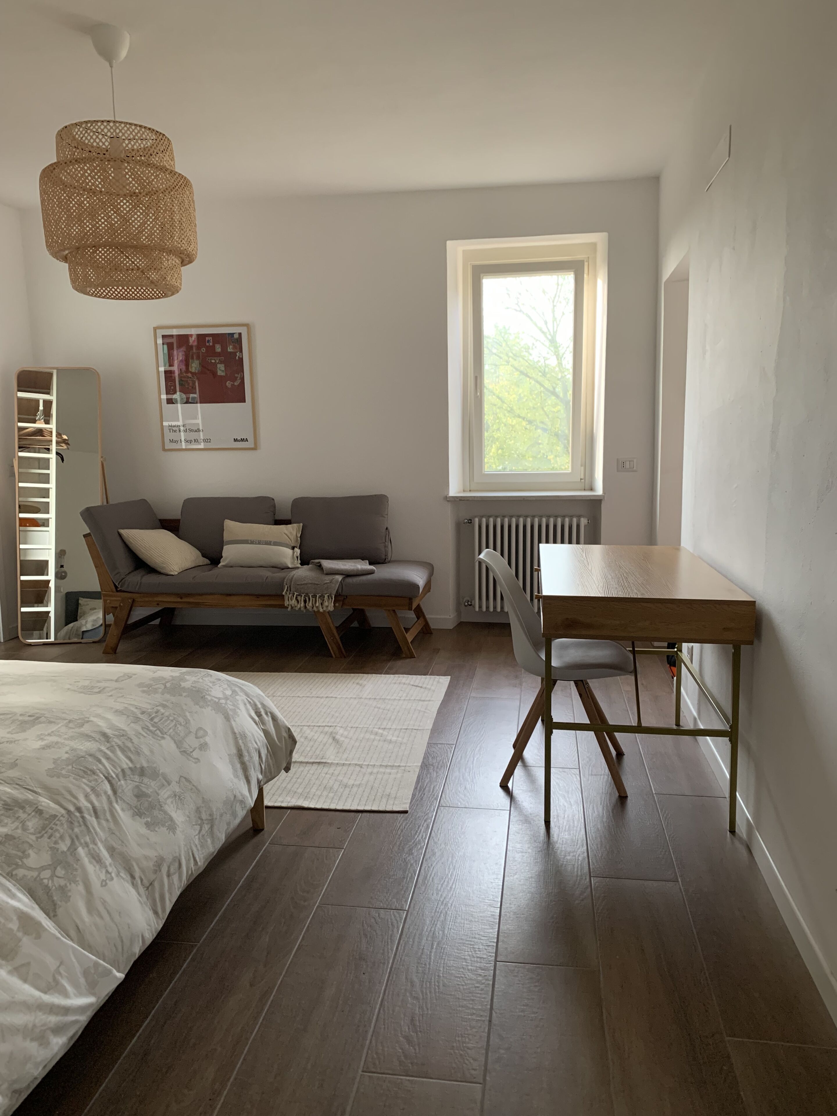 Une chambre moderne avec un lit, un canapé, une table à manger et une fenêtre.