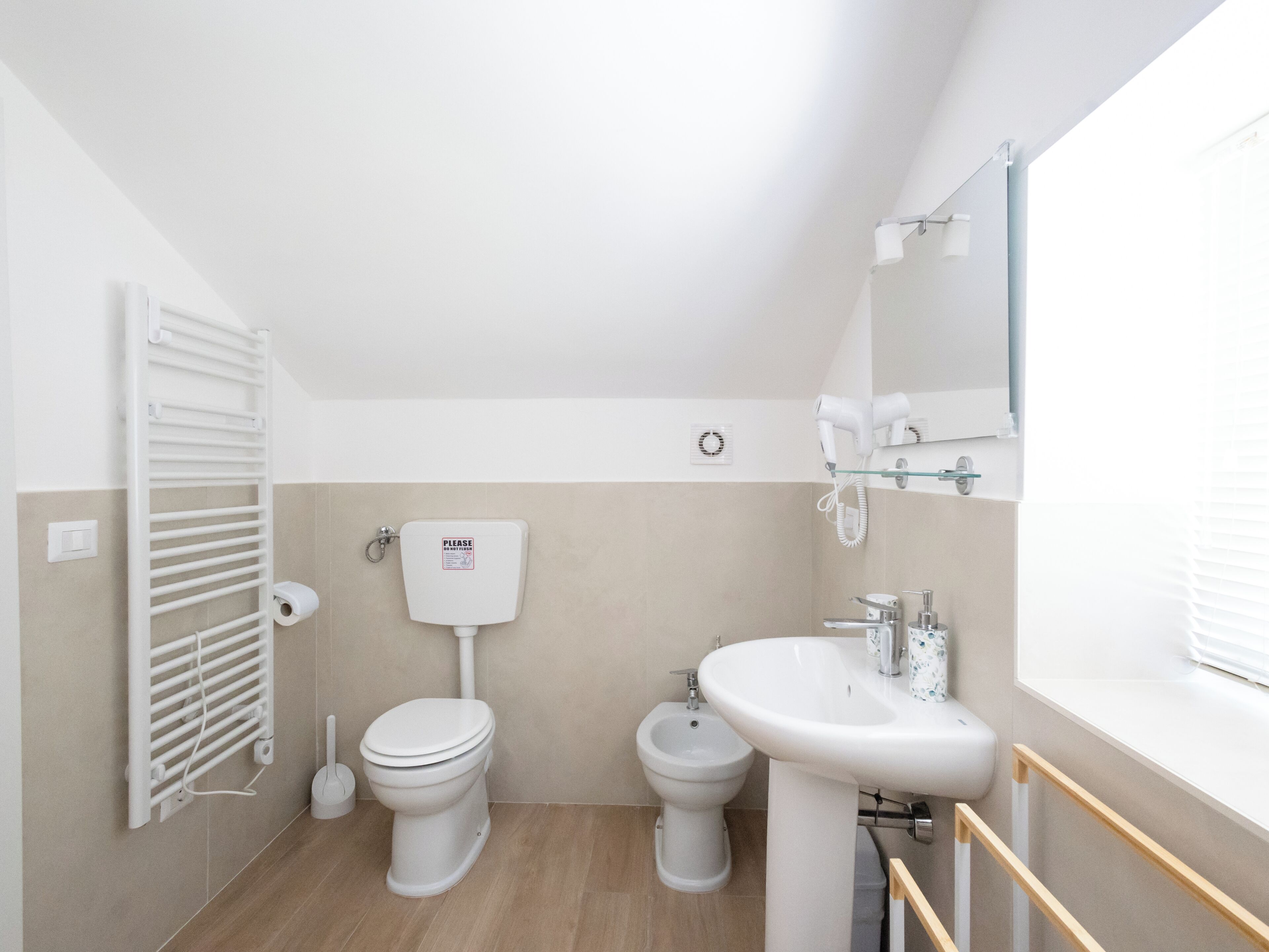 A bathroom with a toilet, bidet, and sink.