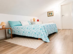 A bedroom with a bed, bedside table, lamp, and a framed picture on the wall. - Sea View Apartment · Porto Rotondo Center · 3BR · Terrace · Walking Distance to the Marina (Porto Rotondo)