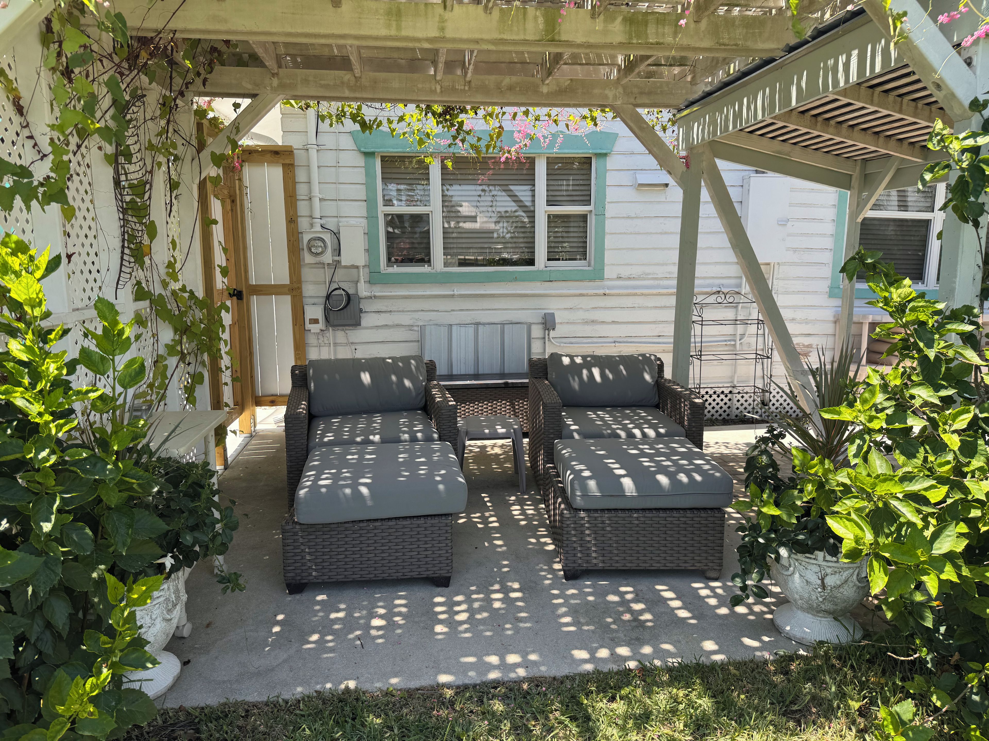 A covered patio area with wicker furniture and a white door.