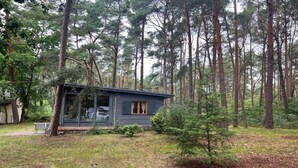 Eine Hütte mit Veranda, umgeben von einem Wald.