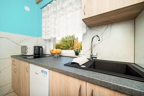 A kitchen with a black sink, a coffee maker, and a dish rack. - Two-story holiday homes with terraces, playground (Mielno)