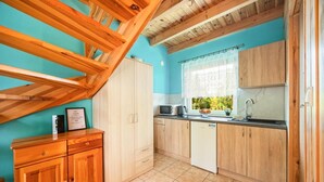 Une cuisine avec des meubles de rangement en bois, un four à micro-ondes et un évier.