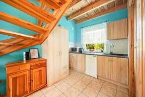 Eine Küche mit Holzausstattung, einer Mikrowelle und einem Spülbecken.