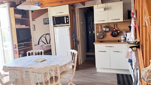 Eine kleine Küche mit Kühlschrank, Mikrowelle und Holzschränken.
