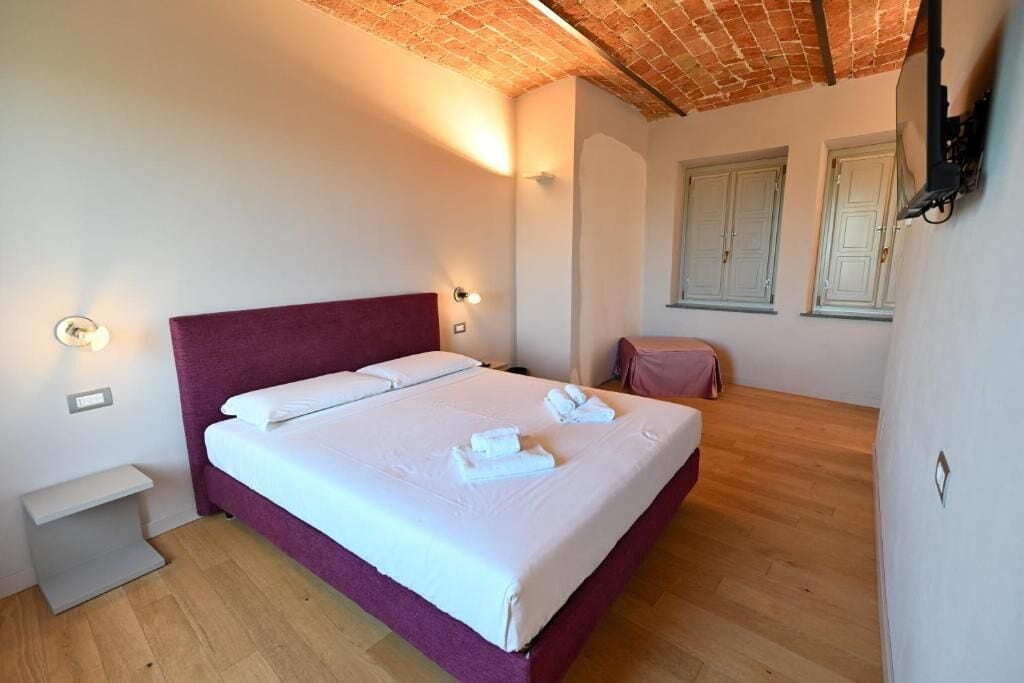A bedroom with a bed, bedside tables, a wardrobe, and a window.