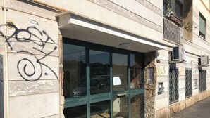 Eine Gebäudefassade mit einer großen Glasdoor, Steinmauern und Graffiti.