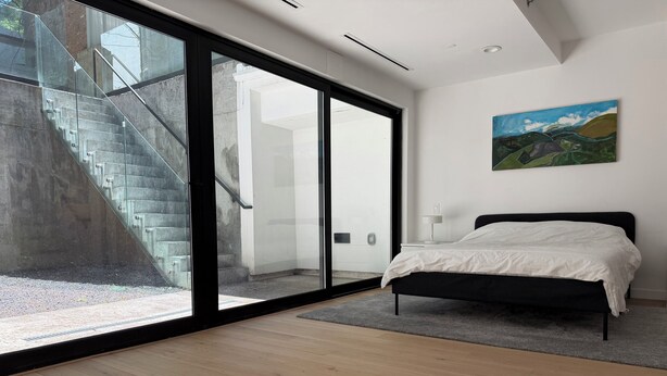 A bedroom with a bed, a painting, and a view of a staircase. - 2 Beds Garden Condo in Fort Greene (Brooklyn)