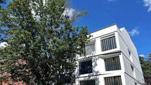 A modern building with a flat facade, large windows, and a visible door number. - 2 Beds Garden Condo in Fort Greene (Brooklyn)