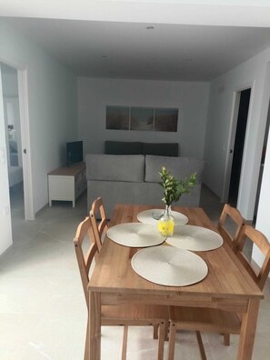 Ein Essbereich mit einem Holztisch, vier Stühlen und einer Blumenvase.