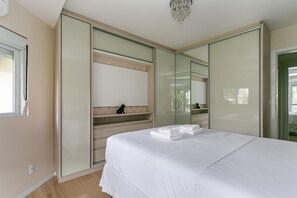 Ein Schlafzimmer mit Bett, Kleiderschrank, Spiegel und Fenster.