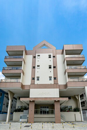 A multi-story hotel with a central atrium, balconies on each floor, and a clear sky above. - Wi-Fi 500MB | 150m from the beach | Pool #IA37 (Florianópolis)