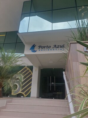 The entrance to Porto Azul Residencial with a modern glass facade and a logo featuring a sailboat. - O AP mais lindo da Praia do Forte 213 (Cabo Frio)