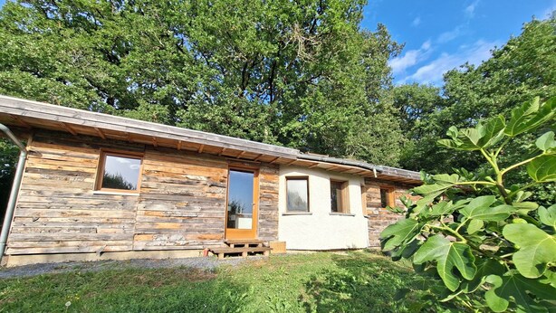 A rustic cabin with a wooden exterior, a front door, and a small porch.